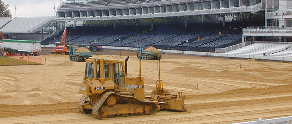 Diggers creating a pitch surface in a stadium
